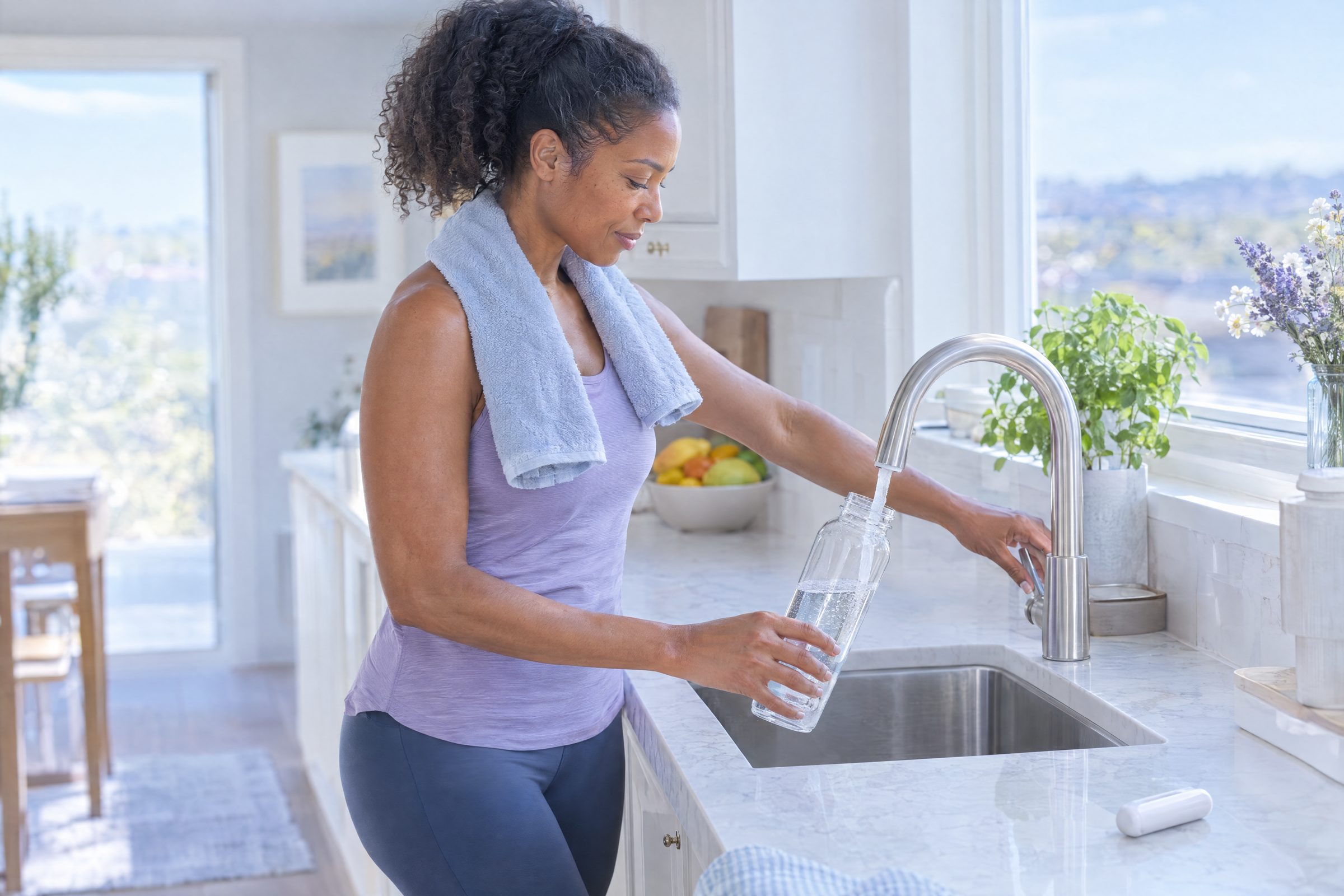 Woman breathing into a small handheld device at the kitchen counter, a coffee cup beside her